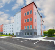 a large apartment building with a parking lot in front of it