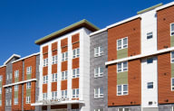 a large apartment building with a blue sky in the background