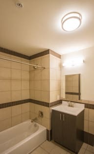 a bathroom with a tub sink and mirror