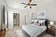 A bedroom with a large bed and a ceiling fan.