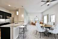 A modern kitchen with a bar area and a dining table.
