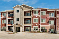 A large apartment complex with a stone pillar entrance.