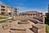 A fire pit sits in the middle of a stone patio.