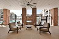 A patio with a table and chairs and a ceiling fan.