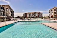 A swimming pool in front of apartment buildings.