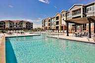A swimming pool in front of apartment buildings.