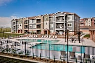 A large apartment complex with a pool in the foreground.