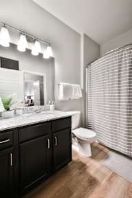 A bathroom with a white toilet, a sink, and a mirror.