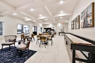 A dining room with a long table and chairs.
