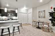 A kitchen with a bar area and a dining table.