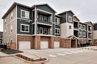 A row of modern townhouses with garages in front.