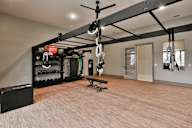 A gym with a pull up bar and weights.