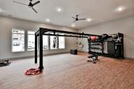 A gym room with a weight rack and a red kettlebell on the floor.