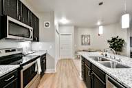 A kitchen with black cabinets and granite countertops.