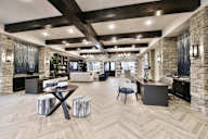 A spacious living room with a stone fireplace and a large wooden table.