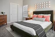 A bedroom with a large bed and a wooden dresser.