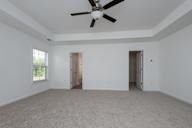 a living room with white walls and a ceiling fan