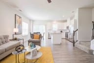 Sun-filled great room with seamless open floor plan, highlighted by tall windows and sophisticated furnishings