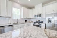 Gourmet kitchen showcasing abundant cabinet space, granite countertops, and perfect entertainment flow