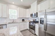 Contemporary kitchen with elegant pendant lighting and spacious preparation areas, ideal for cooking enthusiasts