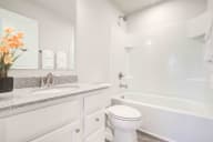 Upscale bathroom featuring an expansive double vanity and luxurious soaking tub with classic white finishes