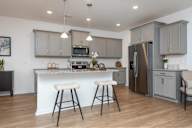 A kitchen with a white countertop and grey cabinets.