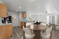 A modern kitchen with a dining table set for four. at Eagles Landing, Ammon, ID