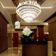 a large glass chandelier hangs above the lobby of a hotel
