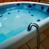 a jacuzzi with a faucet on the side of it