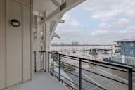 A balcony with a black railing and a white wall.