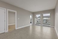 A large empty room with a door and a window.