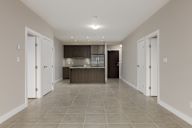 A spacious kitchen with white cabinets and a dark countertop.