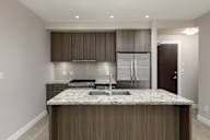 A kitchen with a granite countertop and stainless steel appliances.