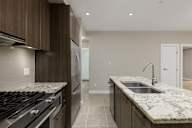 A modern kitchen with granite countertops and stainless steel appliances.