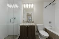 A modern bathroom with a marble countertop and a walk-in shower.