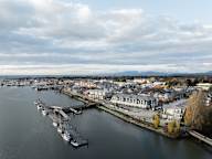 A marina with boats docked and buildings in the background.