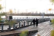 Two people walking on a wooden pier.