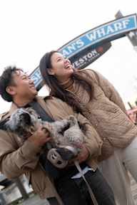A man and woman holding a dog in front of a sign that says "Southampton Wharf Weston".
