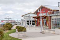 A modern building with a red roof and glass windows.