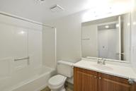 A white bathroom with a toilet, sink, and bathtub.