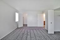A room with a carpeted floor and white walls.