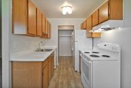A kitchen with wooden cabinets and white appliances.