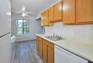 A kitchen with wooden cabinets and a white dishwasher.