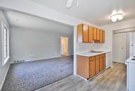 A kitchen area with wooden cabinets and a white fridge.