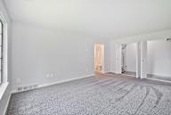 A large empty room with a carpeted floor and white walls.