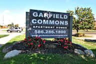 A sign for Garfield Commons Apartment Homes with a website listed.