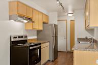 a kitchen with wood cabinets and stainless steel appliances and a refrigerator