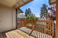 the view from the deck of a home with a wooden railing