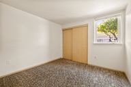 an empty room with a window and a door to a closet