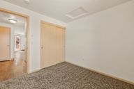 a living room with a door to a hallway and a carpeted floor